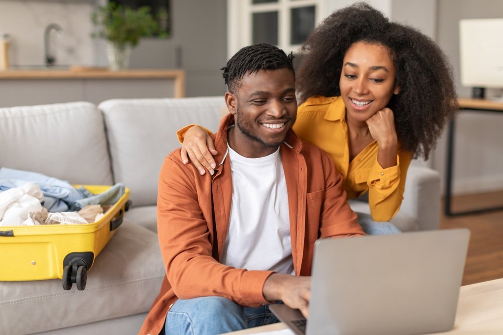 Casal em frente ao computador procurando assuntos referentes a viajar no Carnaval